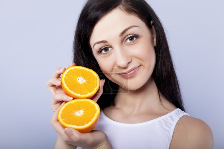 Young happy girl with orange in her hands
