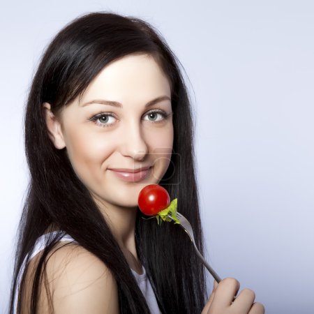 Portrait of a beautiful woman with a tomato