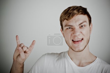 Young man with characteristic heavy metal hand gesture