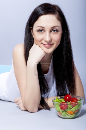 Young smiling woman with vegetables.