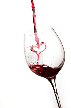 Pouring a heart of red wine in a glass