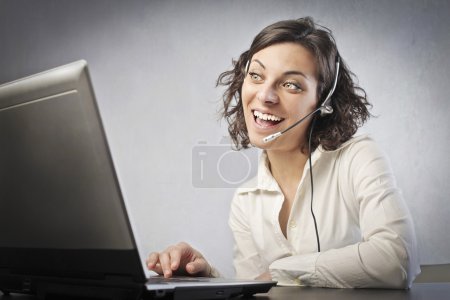 Smiling female operator in front of a laptop