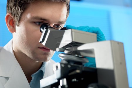 Scientist looks into microscope