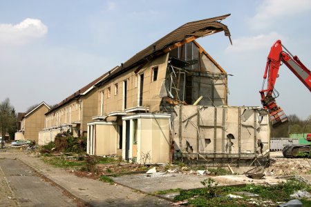 Demolished house with excavator