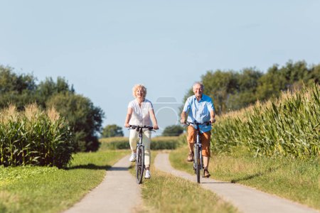 Senior couple looking forward with confidence while riding bicyc
