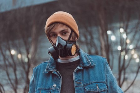 portrait of young man in respirator and hat