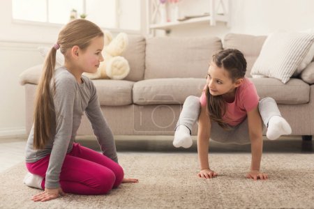 Little girls training yoga together indoors