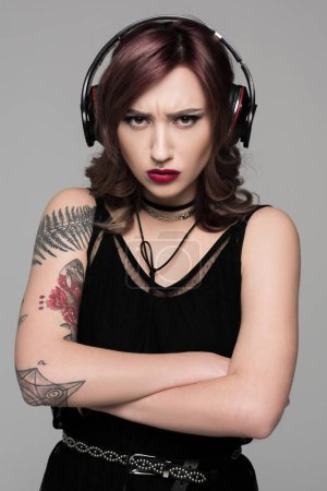 Grumpy young woman in big headphones