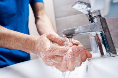 cropped view of doctor washing soapy hands in clinic 