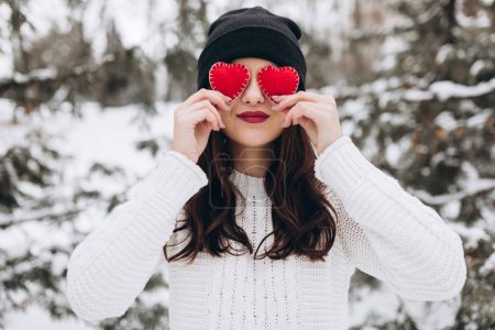 Girl holding hearts in winter nature