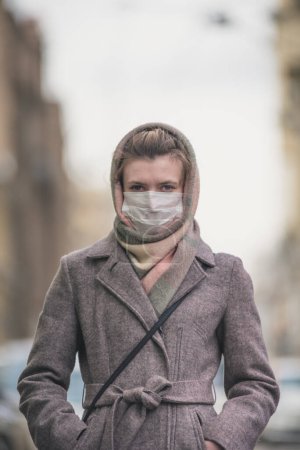 Young woman in a protective mask against viruses on the street