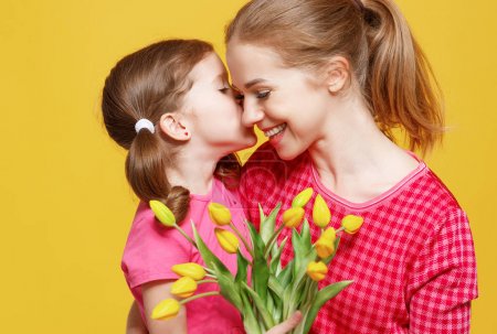 concept of mother's day. mom and child with flower on colored ba