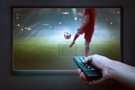 People hands with remote watching football game on the tv