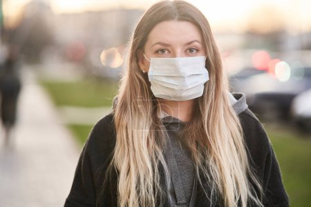 Girl in a medical mask on the background of the city. Coronavirus. Prevention of viral diseases