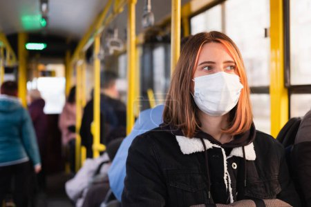 Young adult commutes in a protective face mask. Coronavirus, COVID-19 spread prevention concept, responsible social behaviour of a citizen