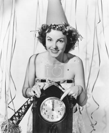Woman pointing at the clock at midnight