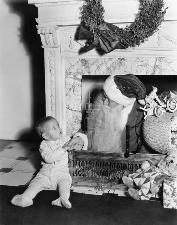 Santa Claus with a little boy in front of a fireplace