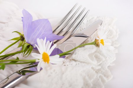 Table fork and knife in a napkin of medieval style, flower