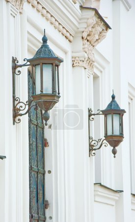 Ancient lanterns on white walls of a monastery