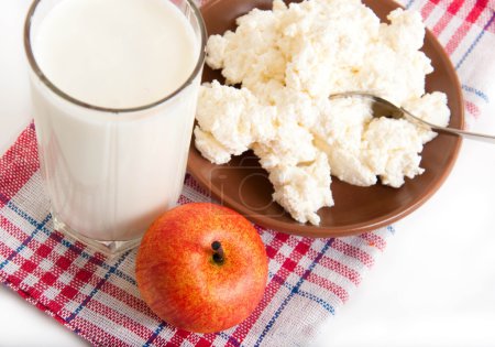 Milk, cottage cheese and apple on the red napkin