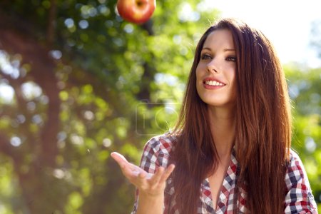 Beautiful woman in the garden with apples