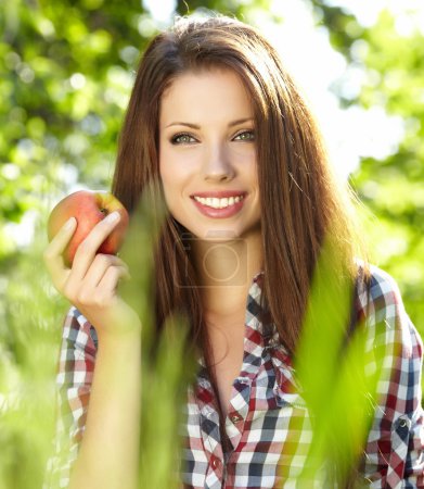 Woman with apple in garden
