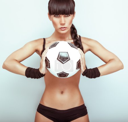 Portrait of a hot young female holding a soccerball