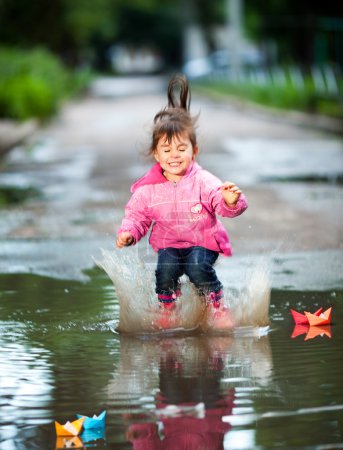 Girl jumps into a puddle