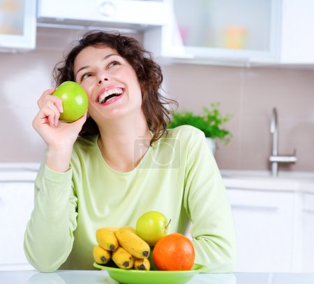 Dieting concept. Laughing Young Woman Eats Fresh Fruit