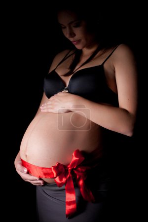 A beautiful pregnant woman with bow on a bump