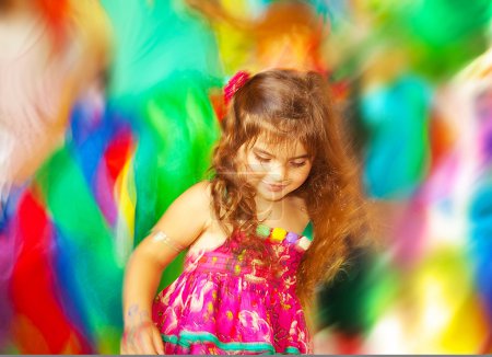 Adorable small girl dancing over blur colors background
