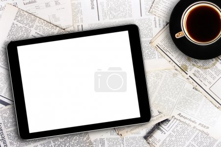 Digital tablet and coffee cup on newspapers